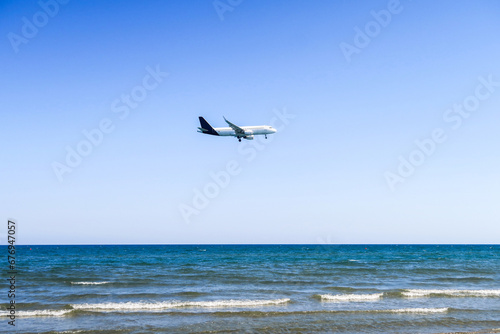 the plane lands over the sea  the beach. The plane flies over the beach umbrellas