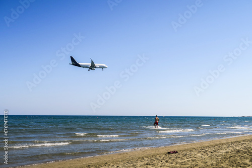 the plane lands over the sea  the beach. The plane flies over the beach umbrellas