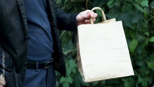 Man pays for food delivery close up .Male courier food delivery man in positive in uniform hands over food order and receives money tips payment from man client in jacket. concept food delivery cash