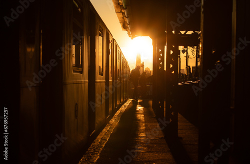 Subway train stopped at station platform during sunset photo