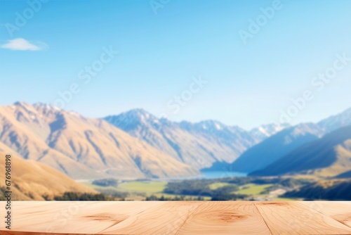 wooden table background and blurred landscape of mountains and sky with sunlight