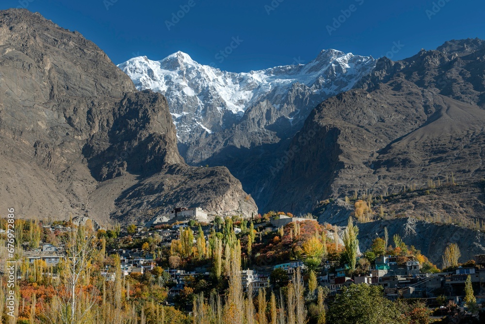 Landscape view of autumn trees with snow-covered mountains in Hunza, Pakistan