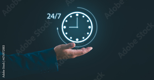 Nonstop service concept. Businessman hand holding virtual 24-7 with clock on hand for worldwide nonstop and full-time available contact of service concept. Customer service, customer care, contact us.