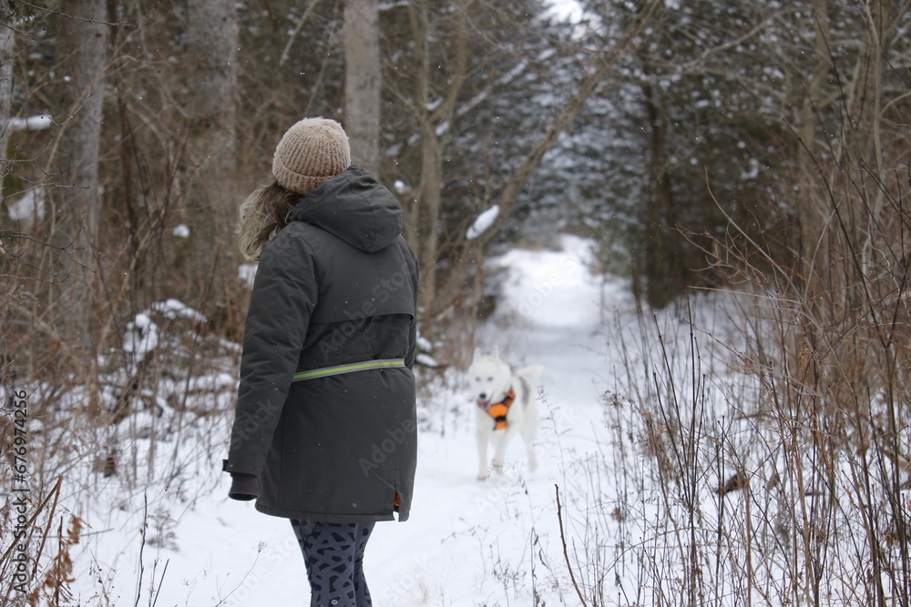 Caucasian woman out in a snowy forest with her husky Caucasian woman out in a snowy forest with her husky