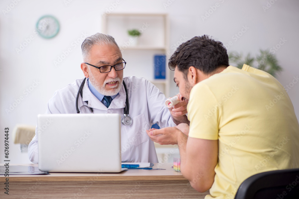 Young male patient visiting old male doctor Young male patient visiting old male doctor