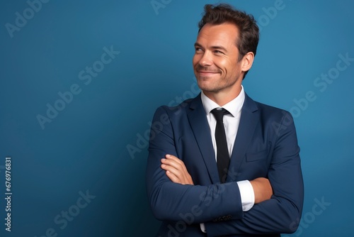 Thoughtful businessman looking at camera, smiling, one color background, generative ai © Nia™