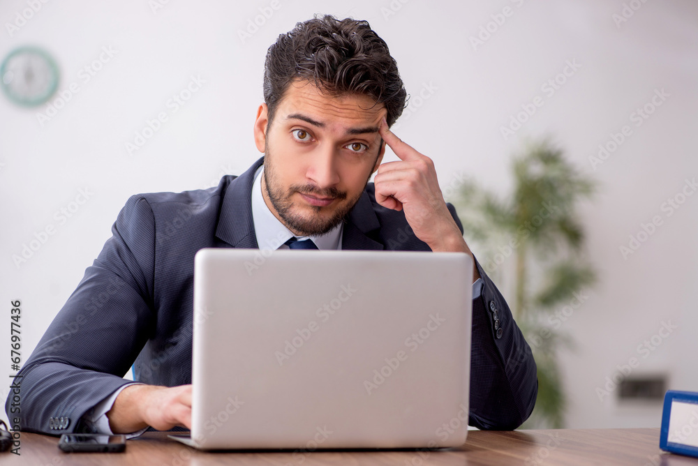 Young male employee working in the office Young male employee working in the office