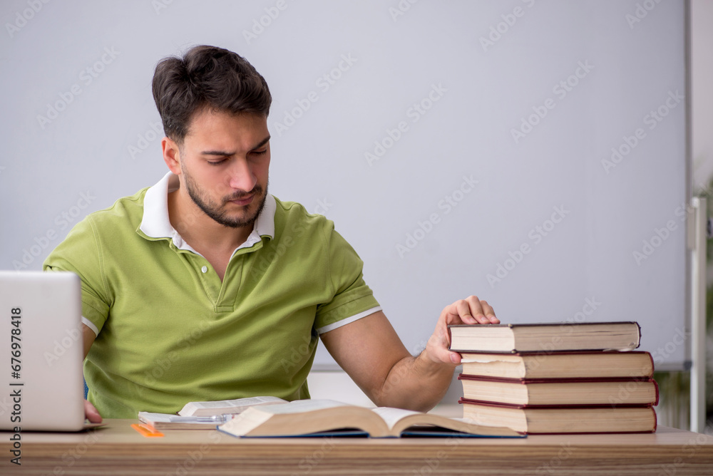 Young male student sitting in front of whiteboard Young male student sitting in front of whiteboard