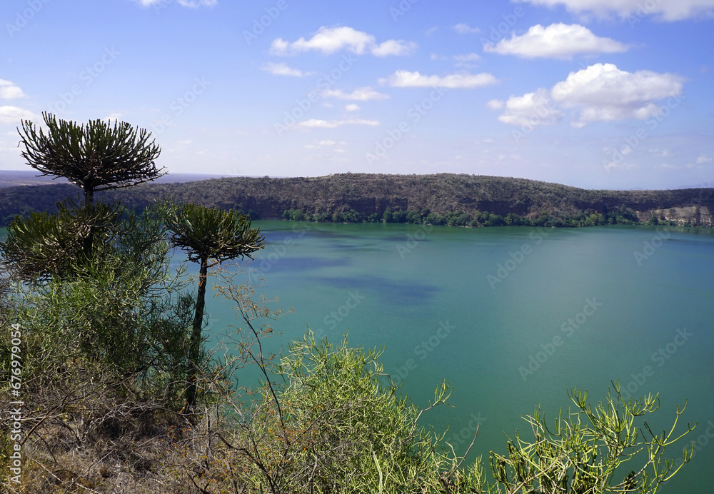 View of Lake Chala crater lake in Tanzania with trees and bushes in the foreground