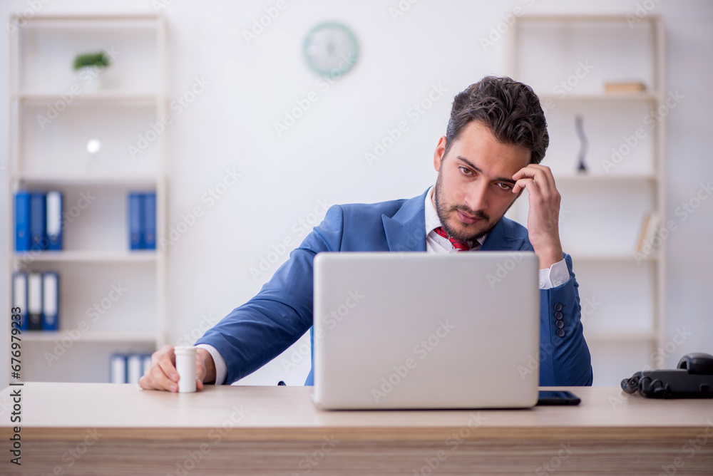 Young male employee feeling bad at workplace Young male employee feeling bad at workplace