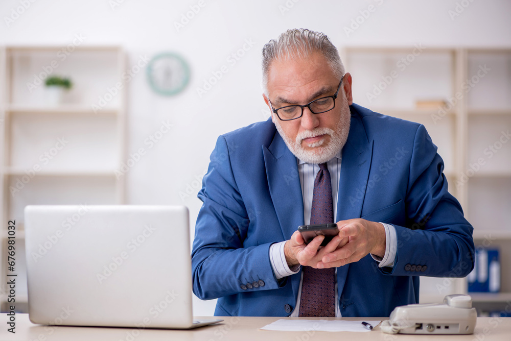Old male employee working in the office Old male employee working in the office