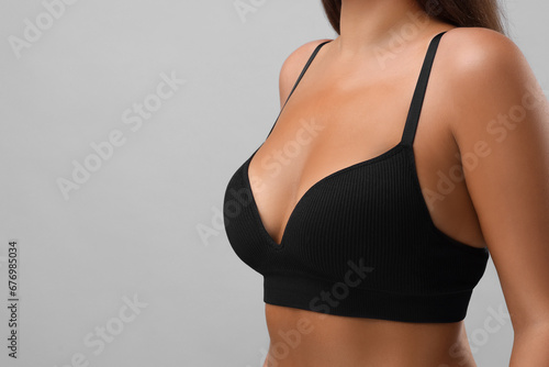 Woman with beautiful breast on light grey background, closeup. Space for text