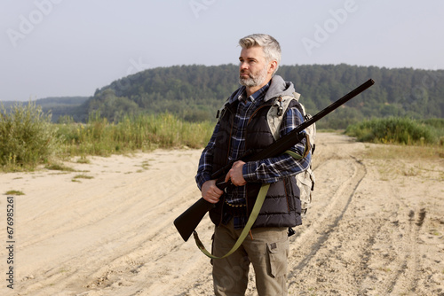 Man with hunting rifle outdoors. Open season