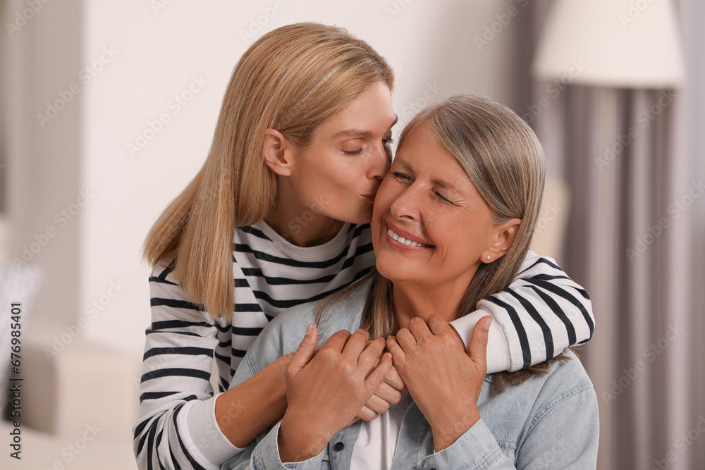 Daughter kissing her mature mother at home Daughter kissing her mature mother at home