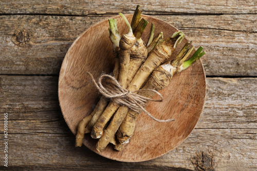 Bunch of fresh horseradish roots on wooden table, top view