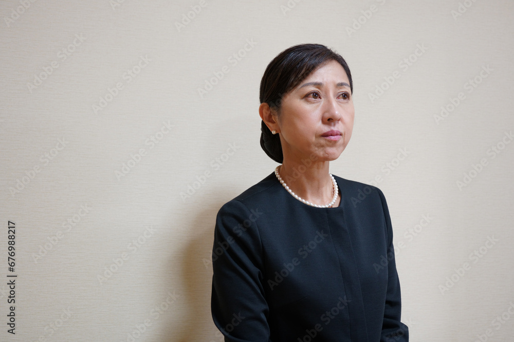 喪服姿で悲しむ中年女性