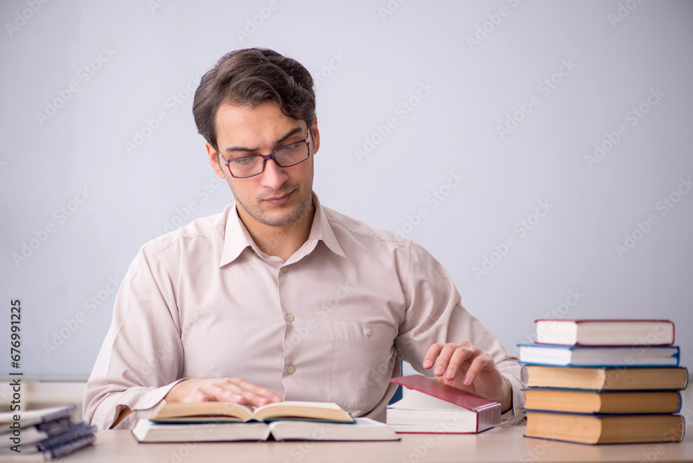 Young male teacher student sitting in the classroom Young male teacher student sitting in the classroom