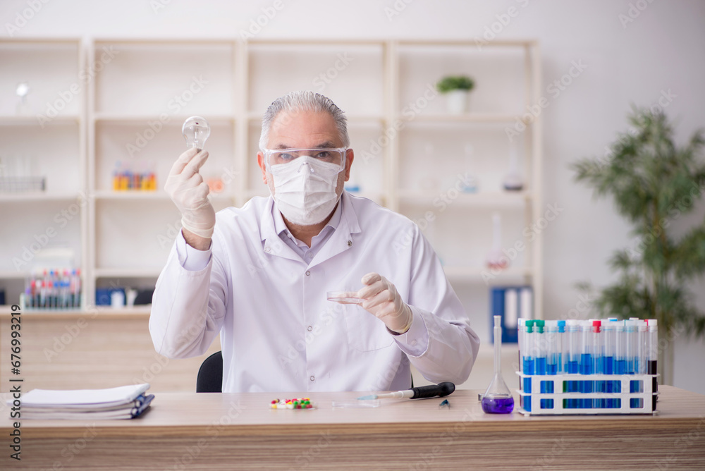 Old male chemist working at the lab Old male chemist working at the lab