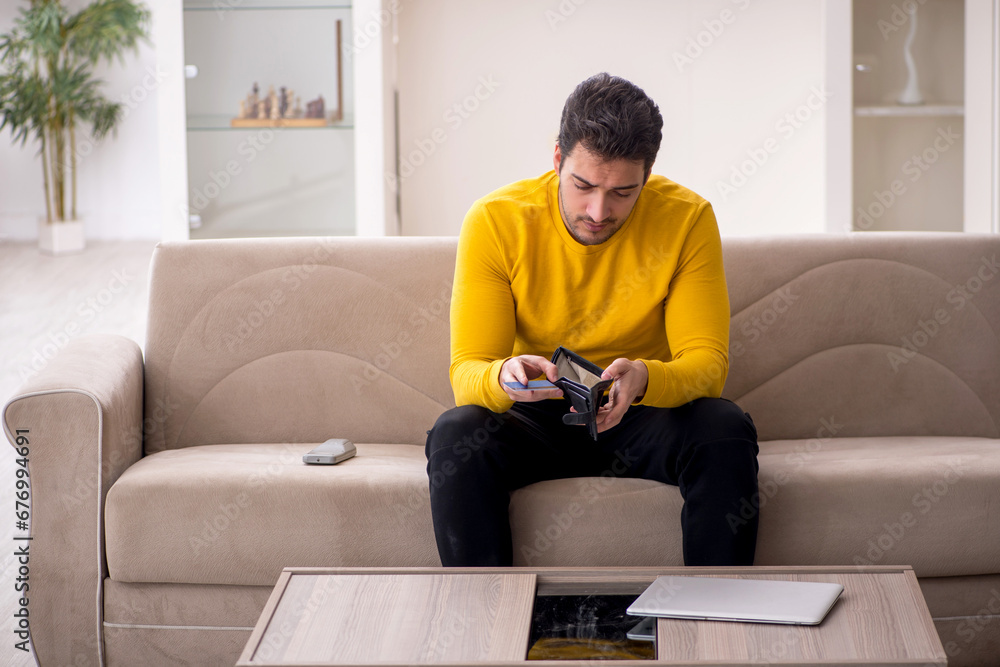 Young man sitting at home in remuneration concept
