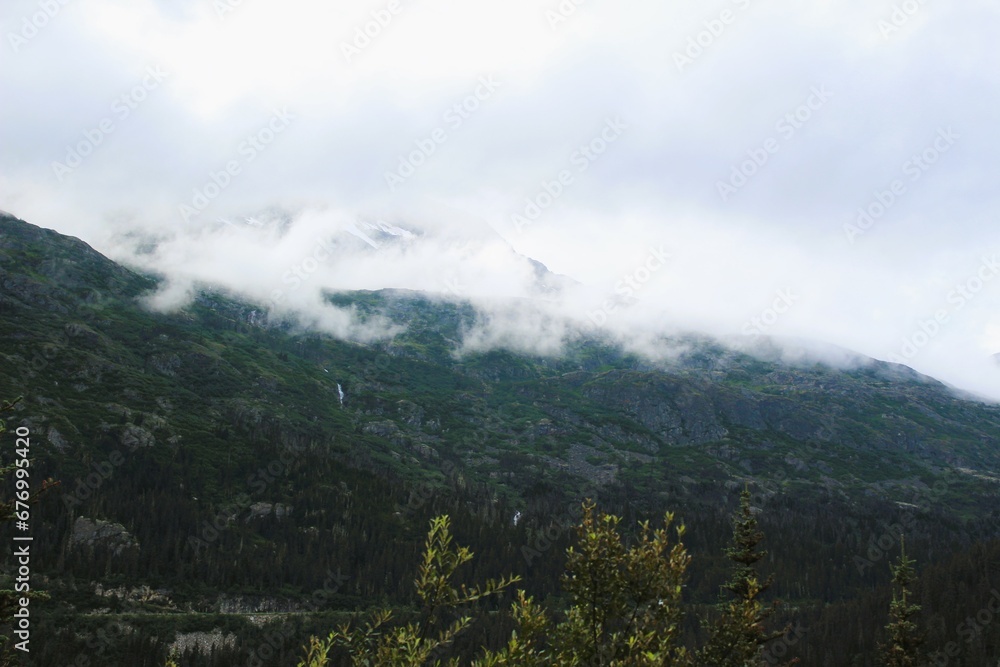 Clouds covered the top of the mountains and Bridal Veil Falls are visible through the trees 