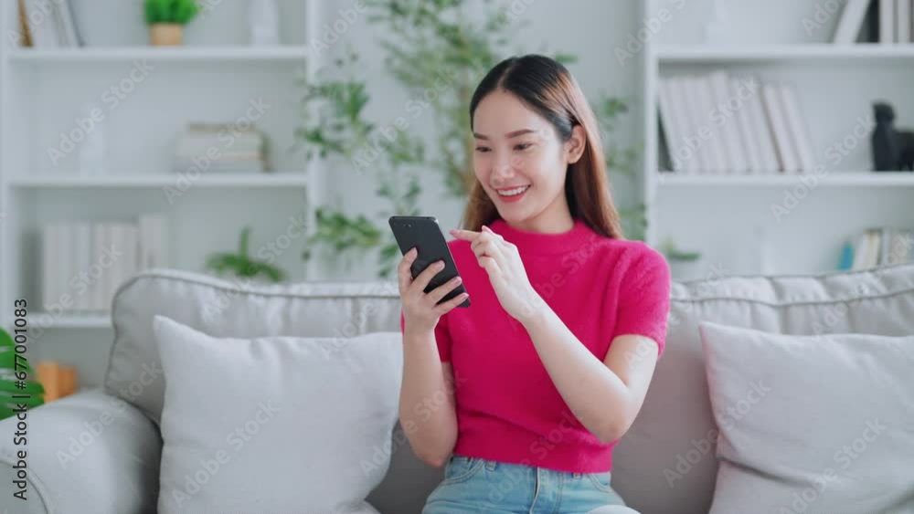 Happy young asian woman relax on comfortable couch at home texting messaging on smartphone, smiling girl use cellphone chatting, online shopping at home, video call communication Happy young asian woman relax on comfortable couch at home texting messaging on smartphone, smiling girl use cellphone chatting, online shopping at home, video call communication