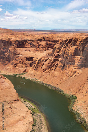 Scenic Vertical Shot of Horseshoe Bend canyon overlooking Colorado River in Page Arizona, USA. Bright Blue Sky.