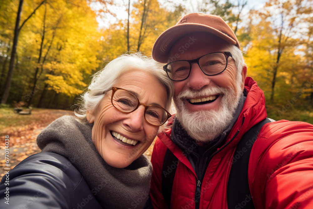 Active seniors taking selfies of them having fun outside in the autumn forest Active seniors taking selfies of them having fun outside in the autumn forest