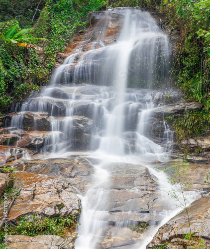 beautiful cascading waterfall over rocks long exposure in Chiangmai Chiang mai mountains northern thailand amongst lush green tropical rainforest