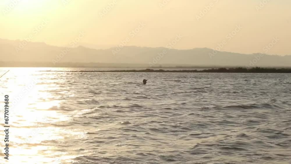 silhouette of a man fishing in the middle of the lake silhouette of a man fishing in the middle of the lake