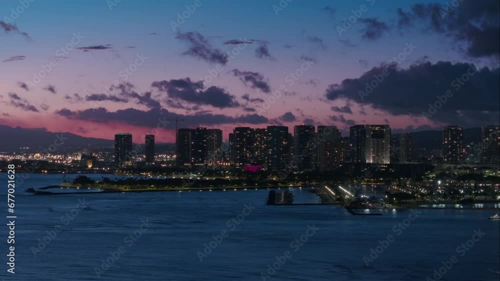 Downtown Honolulu at pink sunset. Scenic Waikiki skyline panorama. Aerial view of downtown at night scene. Beautiful urban landscape of coastal bay city at dusk. City lights in purple sunset Hawaii US Downtown Honolulu at pink sunset. Scenic Waikiki skyline panorama. Aerial view of downtown at night scene. Beautiful urban landscape of coastal bay city at dusk. City lights in purple sunset Hawaii US