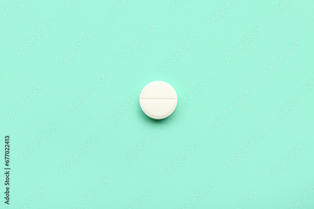 White medical pill on turquoise background White medical pill on turquoise background