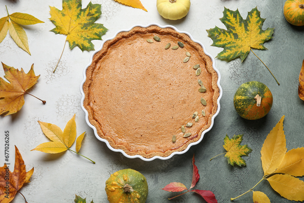 Autumn composition with tasty pumpkin pie on grey background Autumn composition with tasty pumpkin pie on grey background
