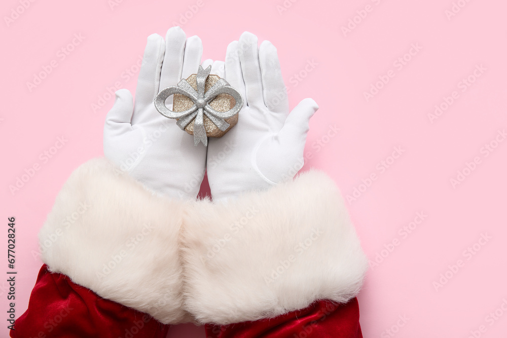 Santa Claus with Christmas gift box on pink background Santa Claus with Christmas gift box on pink background