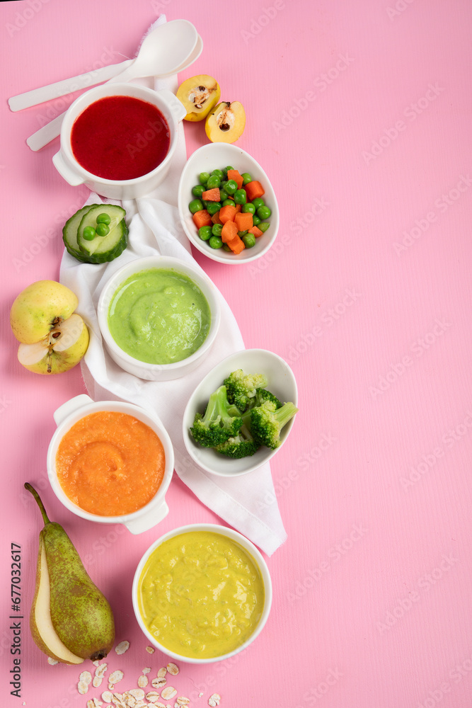 Bowls with baby food on pink background. Healthy eating concept. Bowls with baby food on pink background. Healthy eating concept.