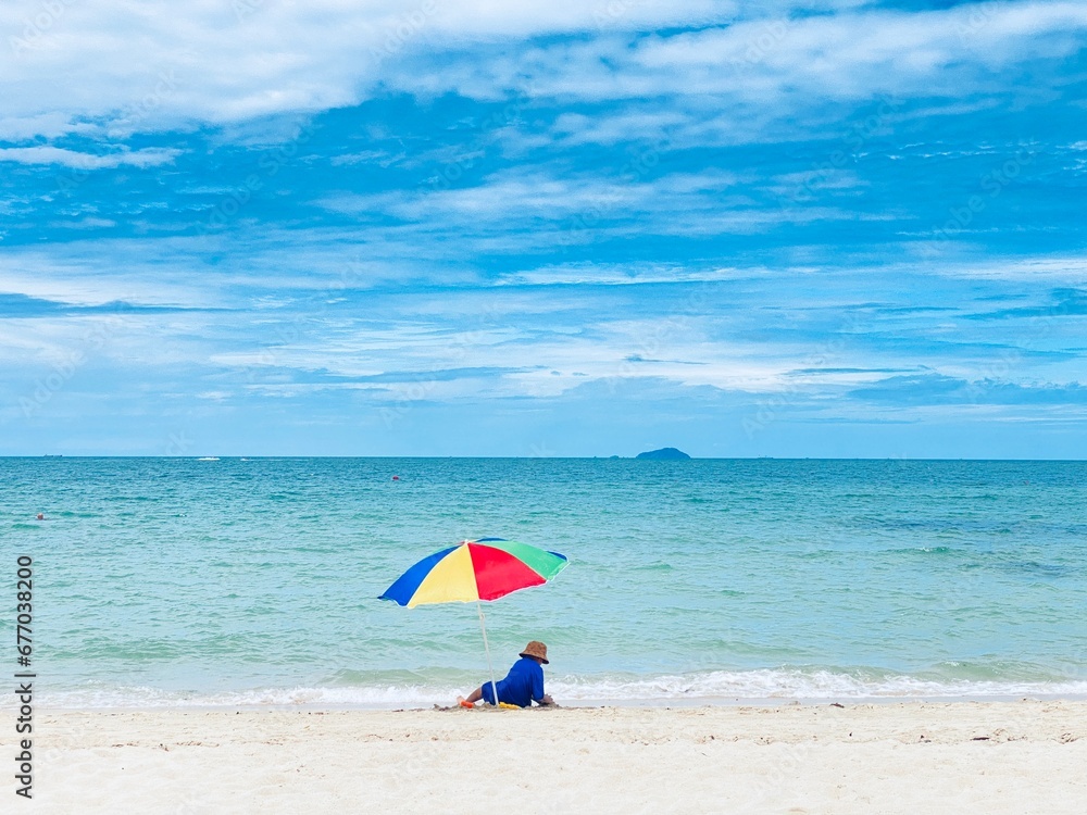 A boy has fun playing with an umbrella in the sand in the sea.
​