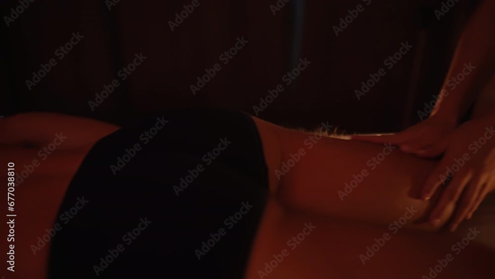 A woman's hand is giving a massage. Massage therapists perform a double four-hand massage. A woman's hand is giving a massage. Massage therapists perform a double four-hand massage.