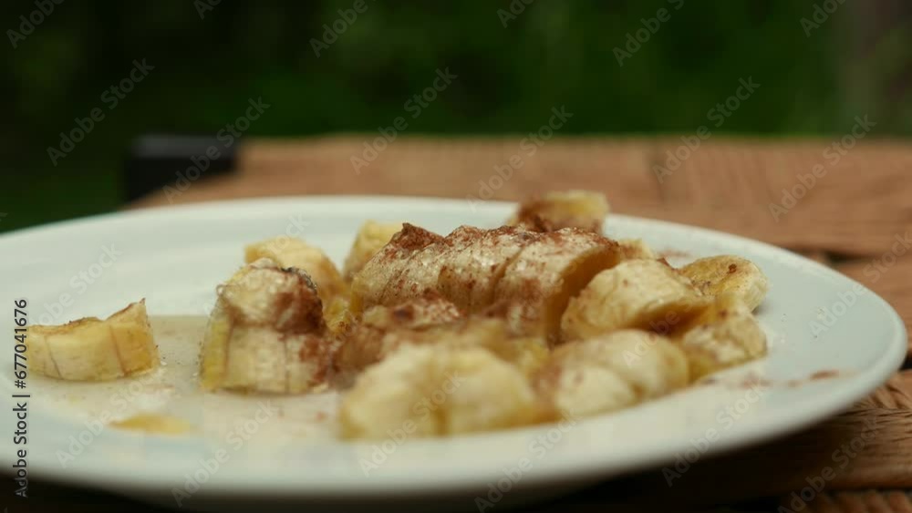 A hot banana candy on the table: banana caramelized with sugar and cinnamon, close-up shot, POV angle. Banana dessert on the table. Caramelized banana with cinnamon. Banana on the table. Homemade food A hot banana candy on the table: banana caramelized with sugar and cinnamon, close-up shot, POV angle. Banana dessert on the table. Caramelized banana with cinnamon. Banana on the table. Homemade food