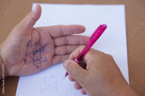 Tablou pe pânză Palm with written physics formula on it during doing writing examination on paper by pen