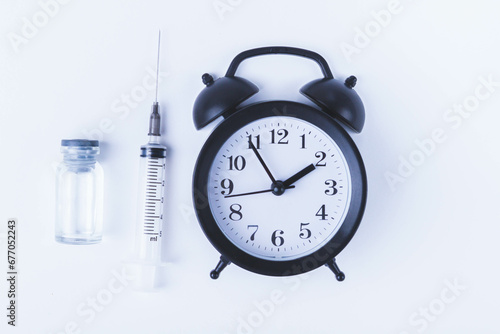 Time for vaccination. Watch and syringe with vaccine. Date and time of preventive vaccinations to population.