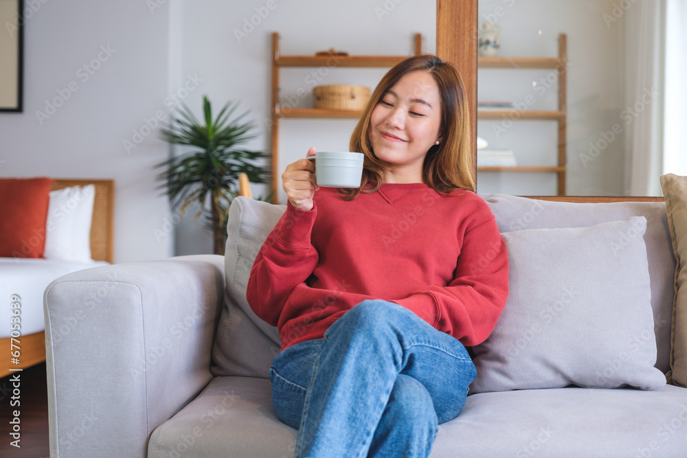 Portrait image of a beautiful woman holding and drinking hot coffee at home Portrait image of a beautiful woman holding and drinking hot coffee at home
