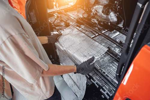 Tunning service worker install soundproofing material inside car interior