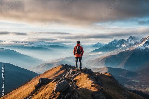 Tourist on the top of a mountain admires the opening mountain landscape.