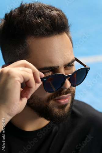 Handsome man in sunglasses outdoors on sunny day