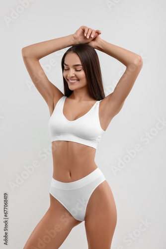 Young woman in stylish bikini on white background