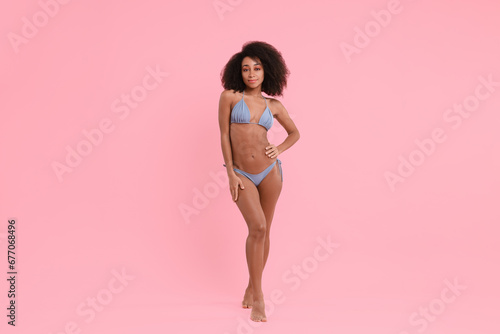 Beautiful woman in stylish bikini on pink background