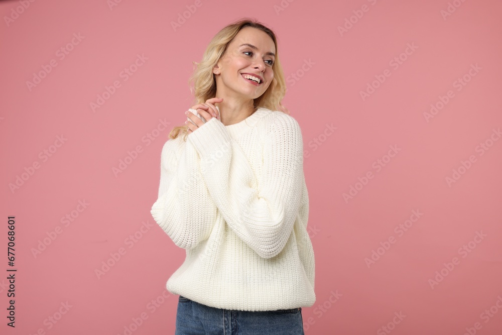 Happy woman in stylish warm sweater on pink background Happy woman in stylish warm sweater on pink background