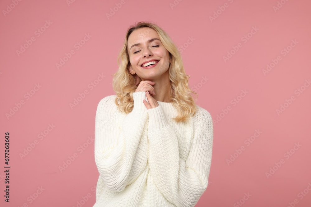 Happy woman in stylish warm sweater on pink background Happy woman in stylish warm sweater on pink background