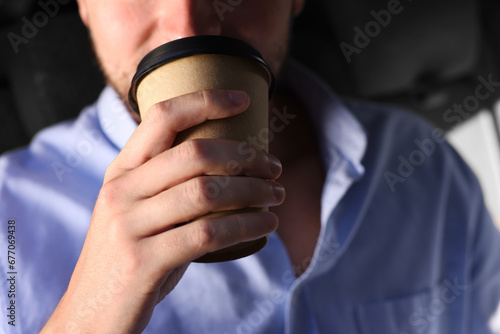 To-go drink. Man drinking coffee in car  closeup