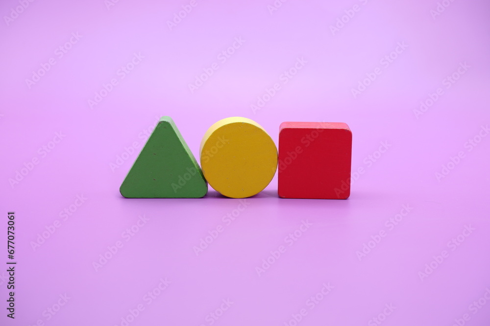 Set of colorful wooden shape toy (Square, triangle, round) on Purple background Set of colorful wooden shape toy (Square, triangle, round) on Purple background