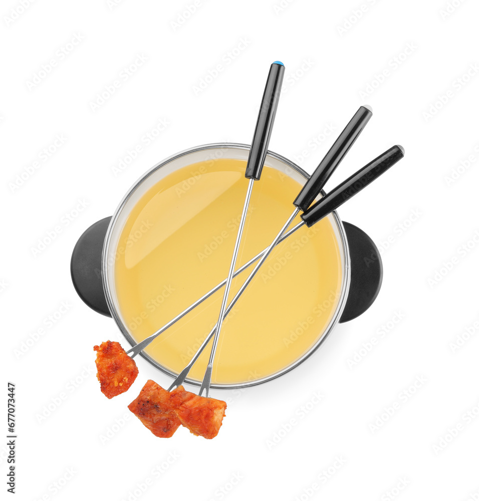 Oil in fondue pot and forks with fried meat pieces isolated on white, top view Oil in fondue pot and forks with fried meat pieces isolated on white, top view